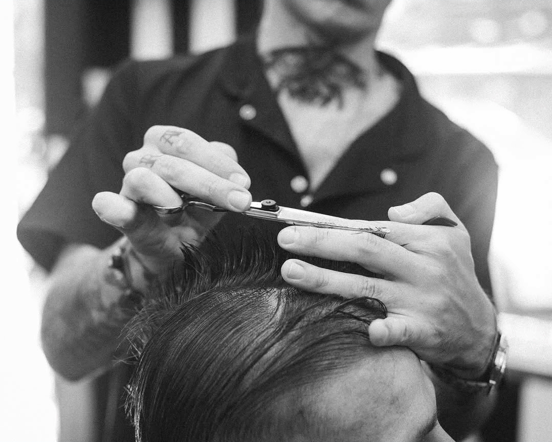 Barbero cortando el cabello con tijera